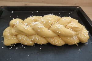 Braided yeast bun sprinkled with crystal sugar